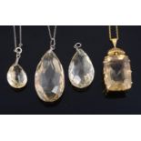 A large rectangular cushion cut citrine pendant and three other citrine pendants