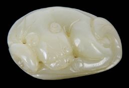 A contemporary Chinese pale celadon carving of a recumbent cat on a leaf