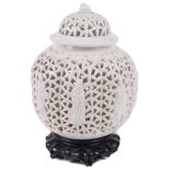 A 19th century Chinese blanc de chine reticulated lobed ginger jar and cove on hardwood stand