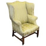 A George III mahogany upholstered wingback armchair