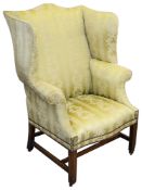 A George III mahogany upholstered wingback armchair