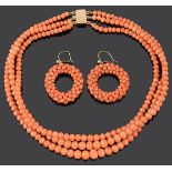 A three row natural coral bead necklace and coral hoop earrings