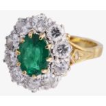 An attractive large emerald and diamond cluster ring