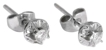 A pair of delicate single stone diamond stud earrings