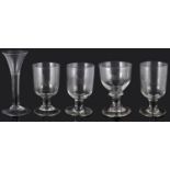 A mid 18th century wine glass and four 19th century pub rummers