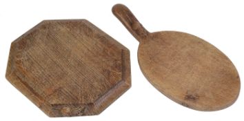 A Robert 'Mouseman' Thompson of Kilburn octagonal oak bread board and oval cheese board with handle