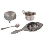 A Persian silver tea stainer and stand, a late Victorian small milk jug and a condiment spoon