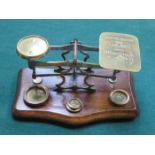 SMALL SET OF VINTAGE BRASS POSTAL SCALES ON MAHOGANY SUPPORT AND WITH FOUR WEIGHTS