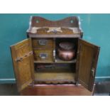 CARVED FRONTED OAK TWO DOOR SMOKER'S CABINET WITH FITTED INTERIOR AND ORIGINAL TOBACCO JAR (AT