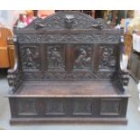 HEAVILY CARVED ANTIQUE OAK PANELLED SETTLE WITH LIFT UP SEAT,