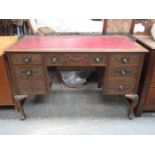 CARVED FRONTED MAHOGANY SEVEN DRAWER LEATHER TOPPED PIERCEWORK DECORATED WRITING DESK WITH