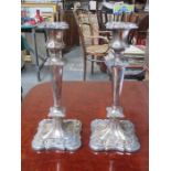 PAIR OF RELIEF DECORATED SILVER PLATED CANDLESTICKS,