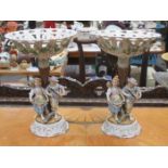 PAIR OF CONTINENTAL HANDPAINTED AND GILDED FIGURE FORM TAZZAS,