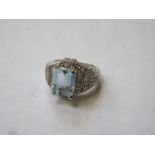 14k WHITE GOLD DRESS RING SET WITH CENTRAL AQUAMARINE COLOURED STONE AND SMALL DIAMONDS