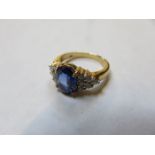 18k GOLD DRESS RING SET WITH CENTRAL SAPPHIRE COLOURED STONE AND SURROUNDED BY SMALL DIAMONDS