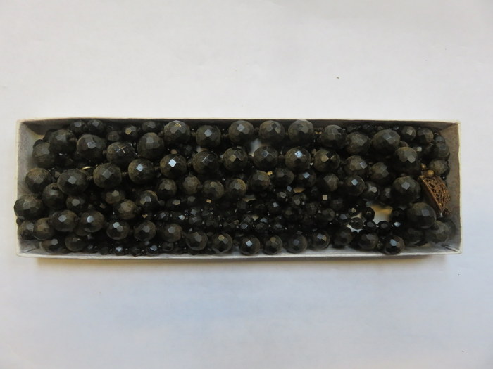 FOUR VARIOUS STRANDS OF BLACK COSTUME BEADS