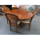 REPRODUCTION CIRCULAR EXTENDING DINING TABLE AND FOUR BERGERE CHAIRS