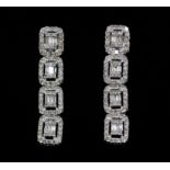 A pair of 18ct white gold (stamped 750) brilliant and baguette cut diamond set drop earrings, L. 1.