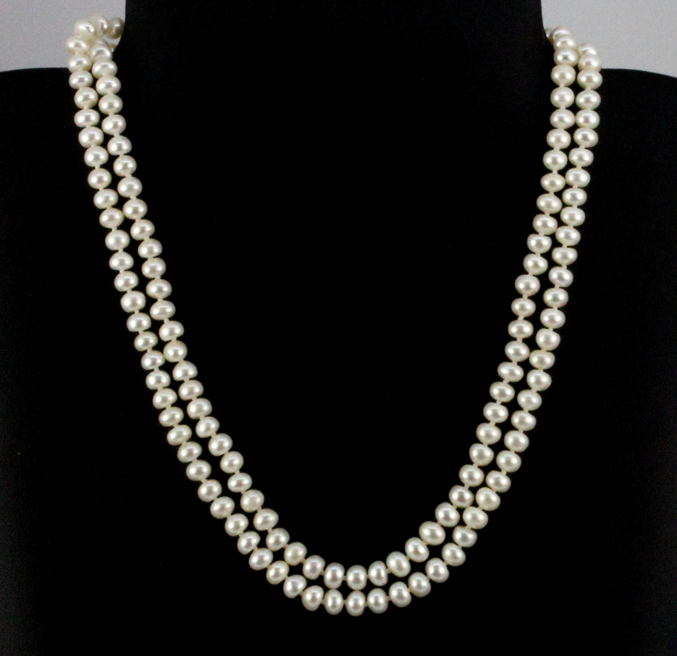 A two row cultured pearl necklace on a white metal clasp, L. 44cm.