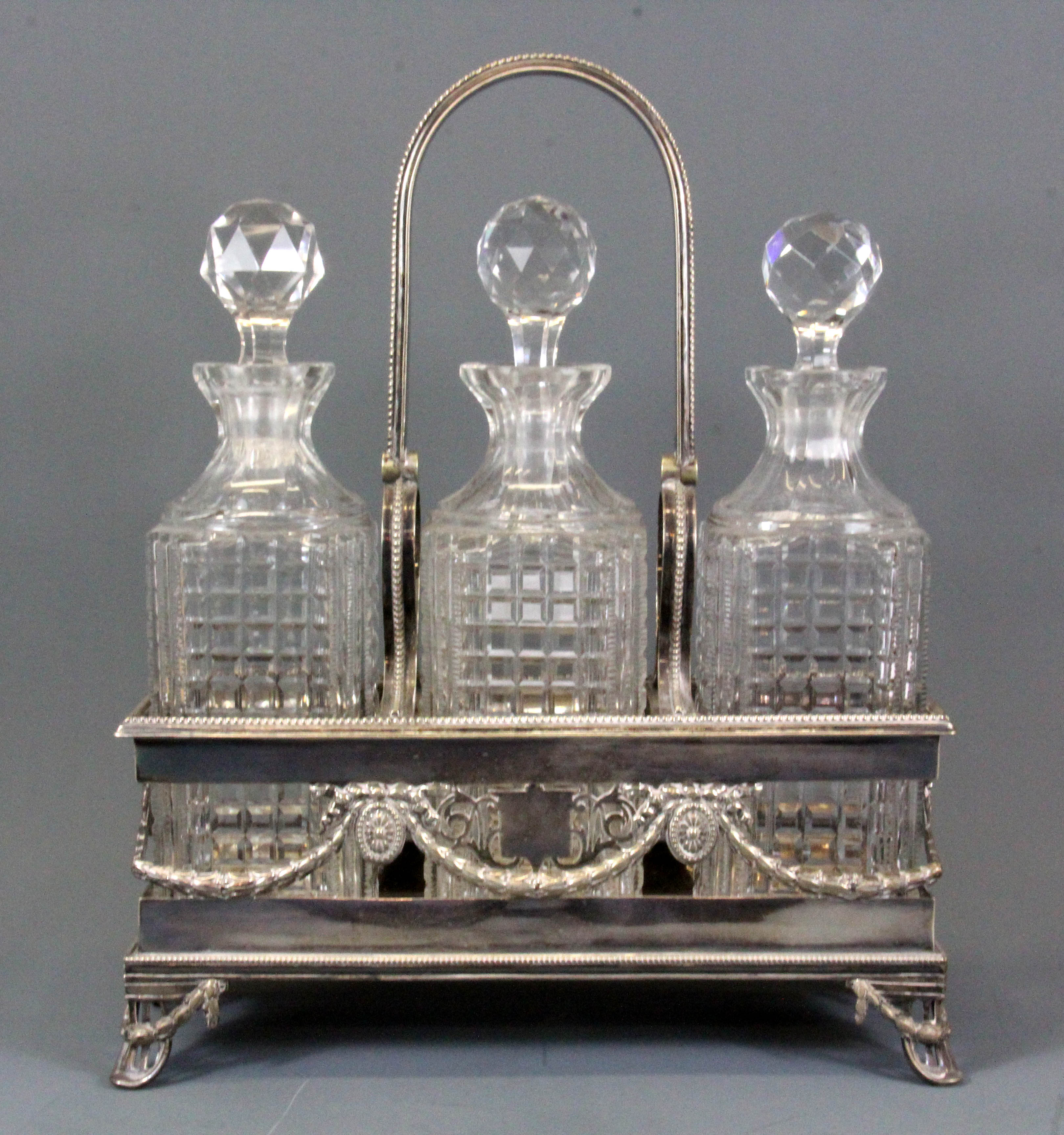 An Edwardian silver plated three bottle tantalus, W. 28cm, H. 34cm.