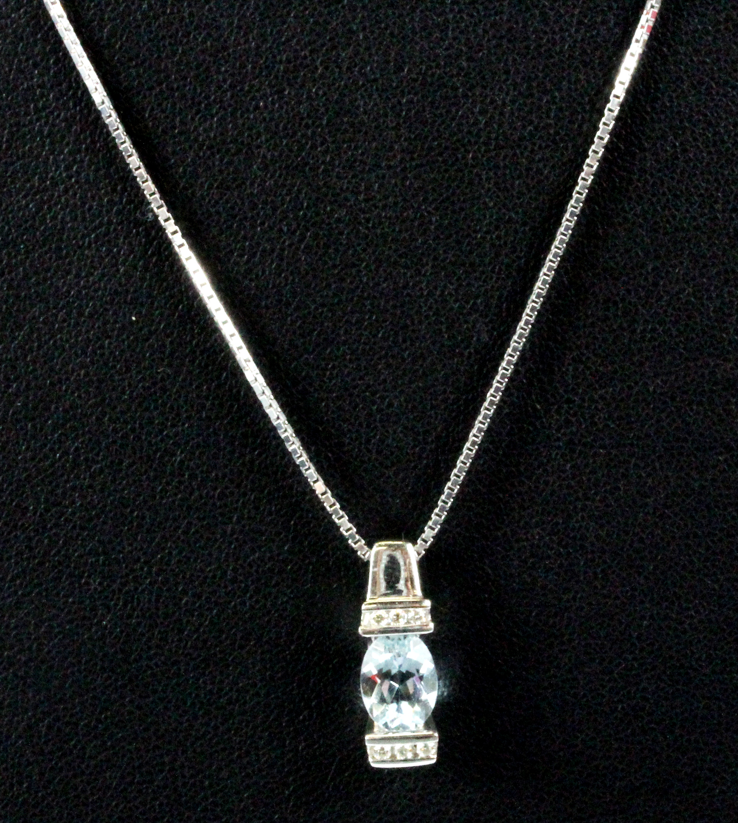 A 14ct white gold aquamarine and diamond set pendant and chain, L. 2cm.