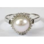 An 18ct white gold (stamped 750) pearl and diamond set cluster ring, (P).