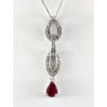 A 9ct white gold ruby and diamond set pendant and chain, L. 3.5cm.