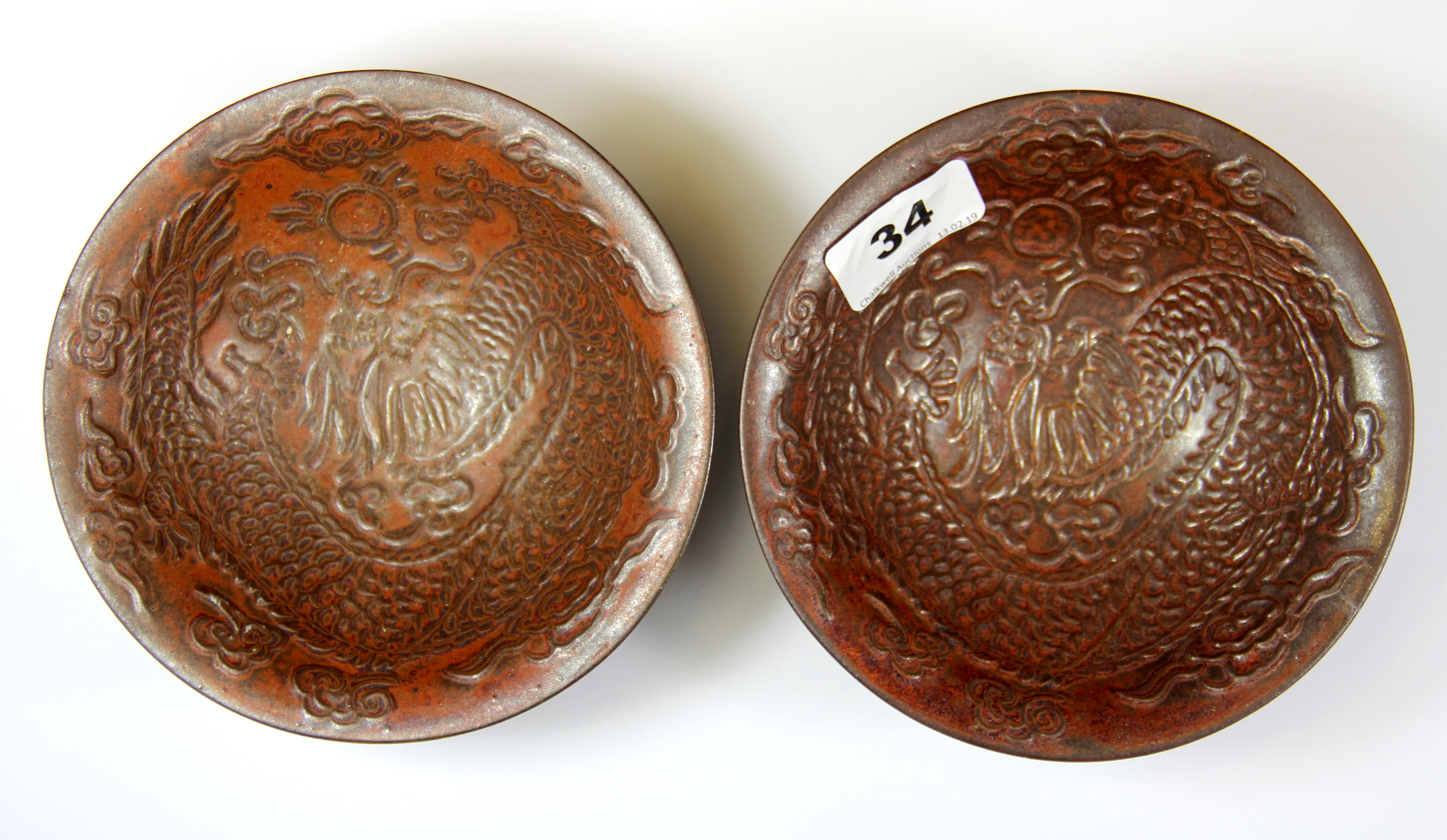 A pair of rare Chinese relief decorated and double skinned porcelain bowls, both decorated with