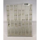 Thirty one pairs of silver and cultured pearl earings on a stand.