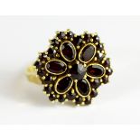 An 18ct yellow gold (stamped 18k) garnet set cluster ring, (P.5).