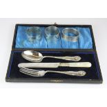 Three hallmarked silver napkin rings and a cased silver plated christening set.