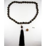 A strand of Tibetan polished nut prayer beads, folded L. 72cm with tassel, together with an