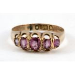 An antique 9ct yellow gold (stamped 9ct) ring set with five pink stones, (P).