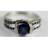 A 9ct white gold sapphire and diamond set crossover ring, (O).