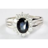 An 18ct white gold sapphire and diamond set cluster ring, approx. 1.25ct sapphire, 0.45ct