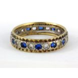 An 18ct yellow and white gold stone set full eternity ring, (M).