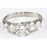 A platinum (stamped PT) five graduated diamond ring, set with a centre brilliant cut 1.