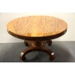 An early 19th century fiddle back mahogany veneered pedestal tilt top dining table, Dia. 121cm.