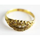 An 18ct yellow gold (stamped 18) seed pearl set cluster ring, (one pearl missing), (N).