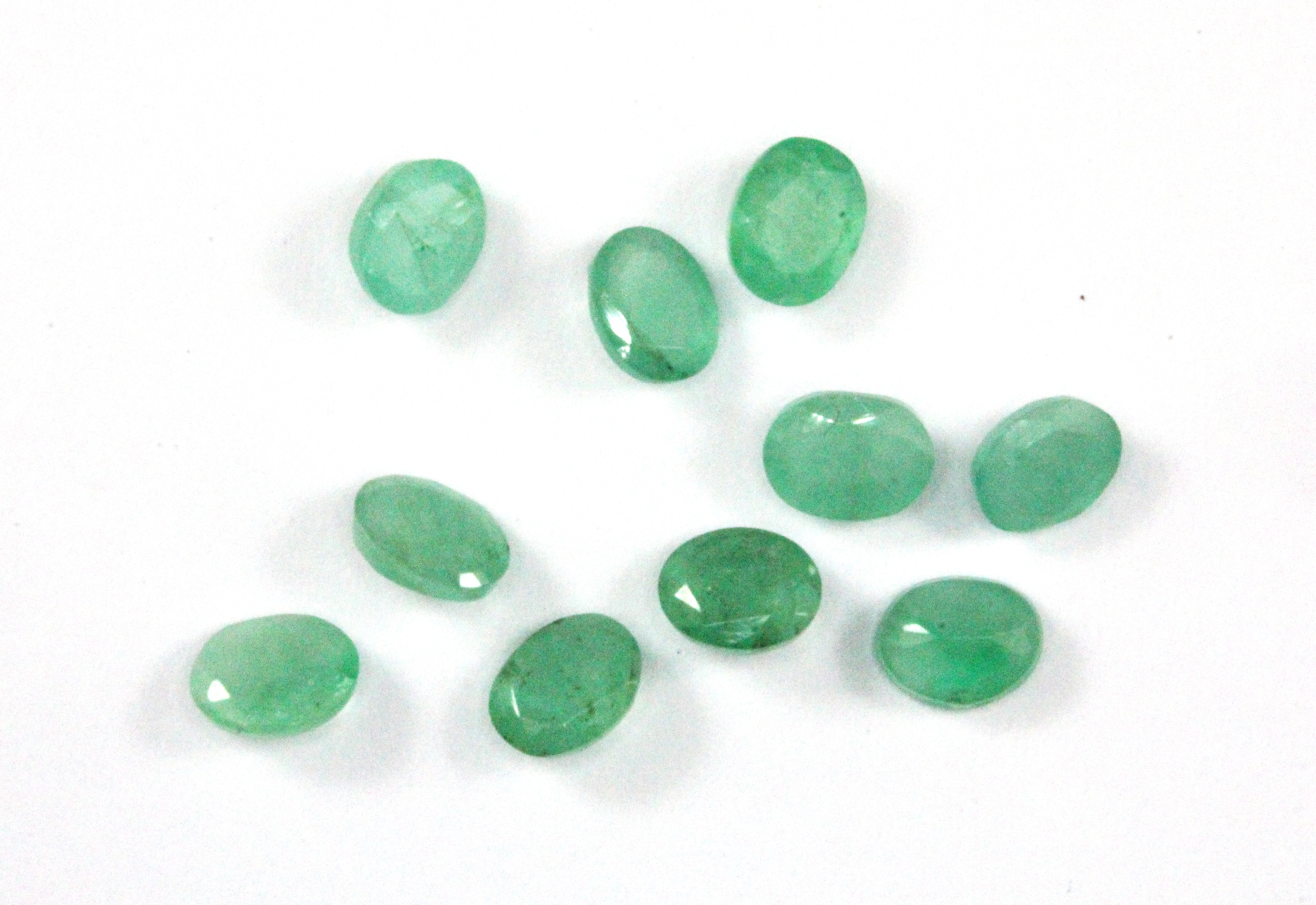 Ten unmounted oval cut emeralds, approx. 3.5ct, 5 x 4mm.