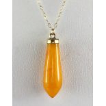 A yellow metal mounted butterscotch amber pendant on a 9ct gold chain, L. 3cm.