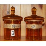 A pair of 19th Century amber glass jars and covers, H. 23cm.