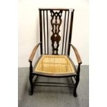 An Arts and Crafts cane seated armchair, H. 85cm.