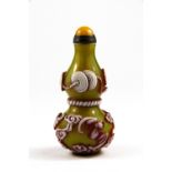 A Chinese three colour carved Peking glass snuff bottle decorated with lucky symbols, with later