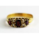 An 18ct yellow gold (worn hallmark) ruby and diamond set ring, (P).