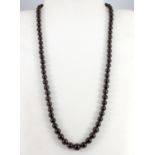 A graduated garnet bead necklace, L. 56.