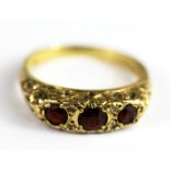 A 9ct yellow gold garnet and white stone set ring, (L).