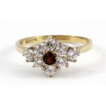A 9ct yellow gold garnet and white stone set cluster ring, (N.5).