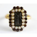 An 18ct yellow gold garnet and pearl set mourning ring.