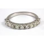 An 18ct white gold (stamped 750) brilliant cut diamond set half eternity ring, approx. 0.85ct, (N).
